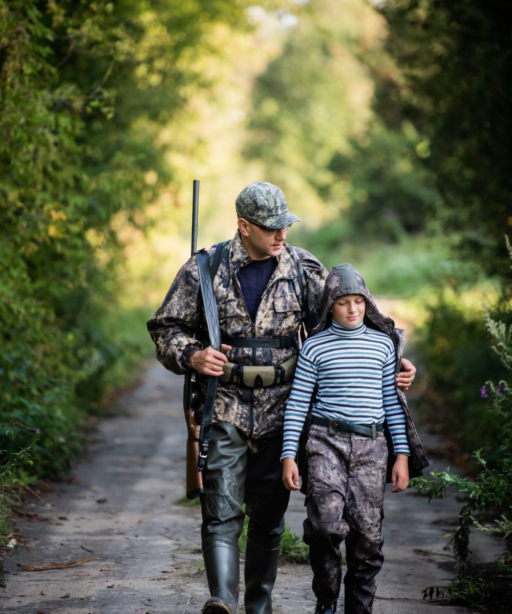 father pointing and guiding son on first deer hunt