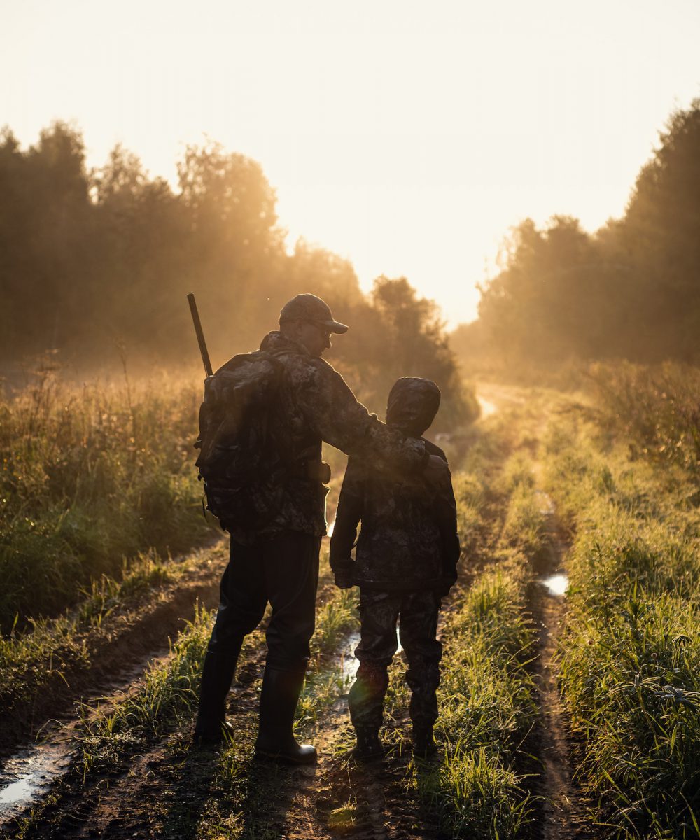 father pointing and guiding son on first deer hunt